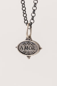 Erica Molinari small fine jewelry Sterling Silver oval dual-sided pendant with a heart shape embossed on the front, and an inscription of the word for love ("AMOR") engraved on the back